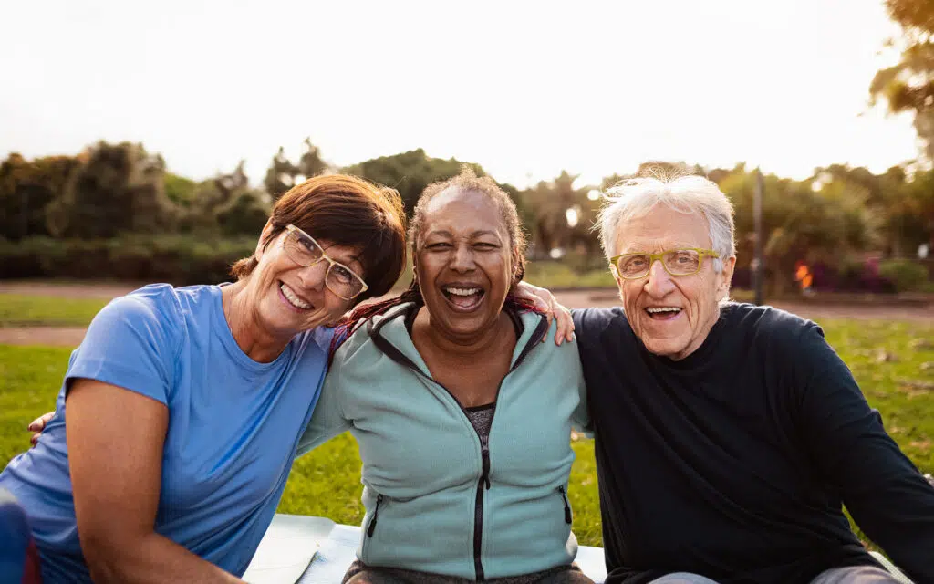 a group of adults with arms around each other smiling